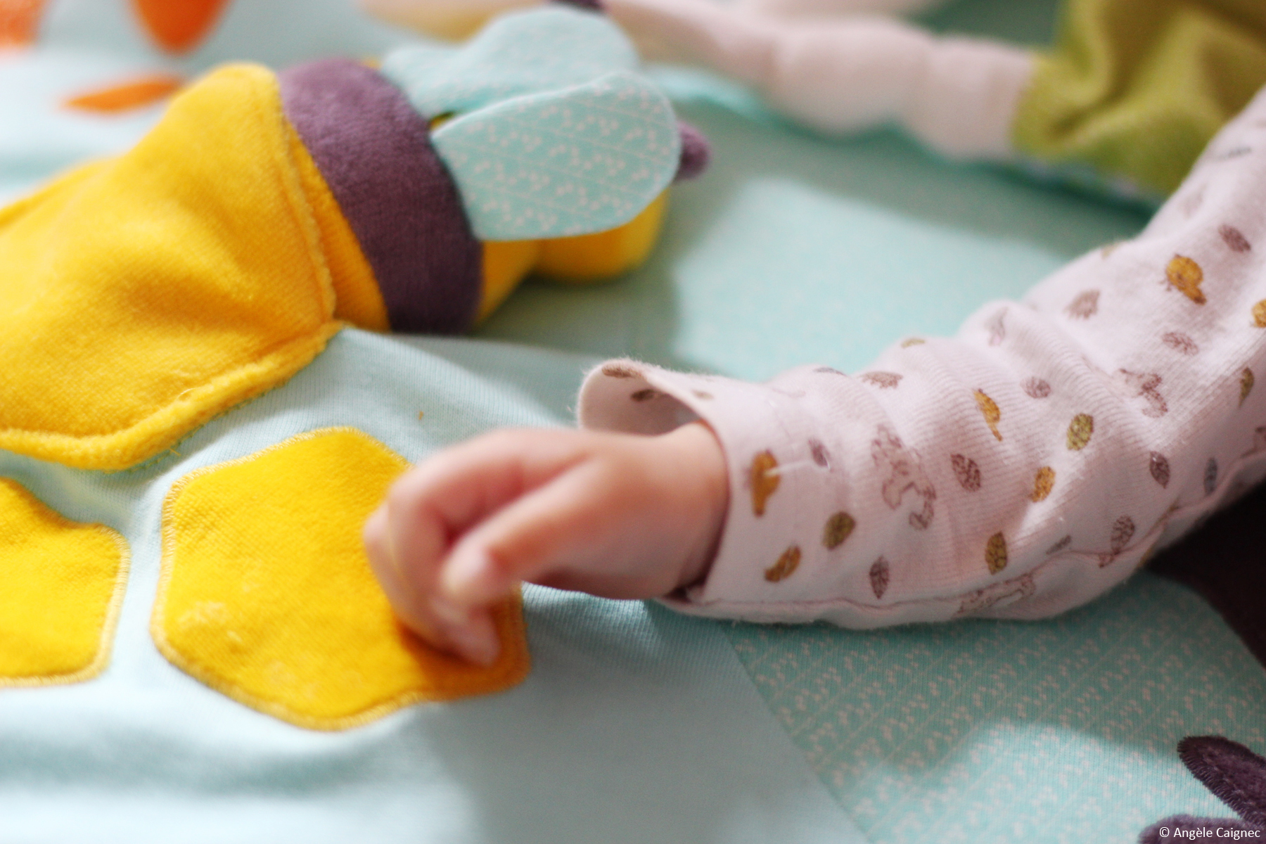 Détail de la main de mon bébé sur son tapis d'éveil